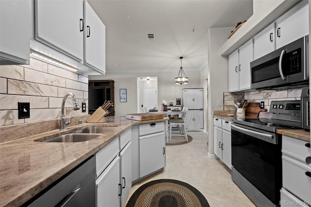 kitchen featuring stainless steel appliances, hanging light fixtures, sink, and white cabinets