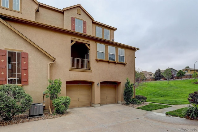 view of front of property featuring a front yard, central AC unit, and a garage