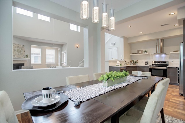 dining area featuring sink, a tile fireplace, and light hardwood / wood-style flooring