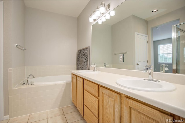 bathroom featuring tile patterned floors, vanity, and tiled tub