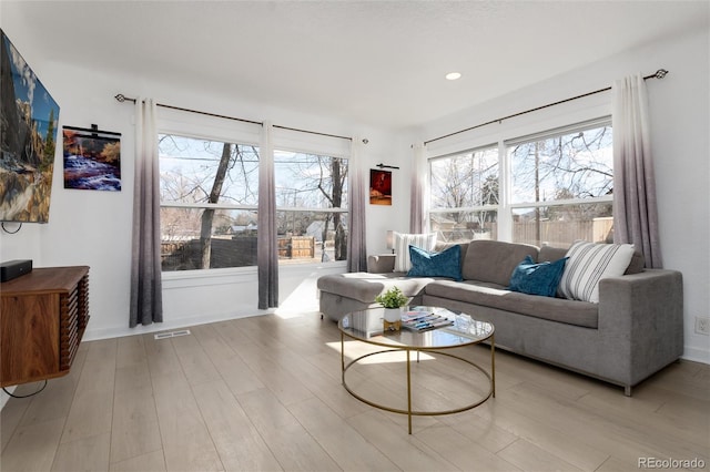 living area featuring light wood finished floors, visible vents, a wealth of natural light, and recessed lighting