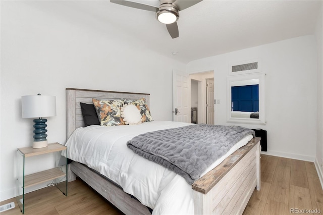 bedroom with light wood-style flooring, a ceiling fan, visible vents, and baseboards