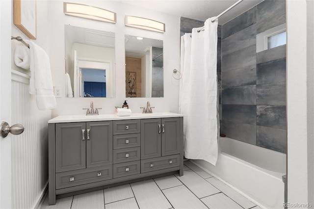 bathroom with double vanity, shower / bathtub combination with curtain, and a sink