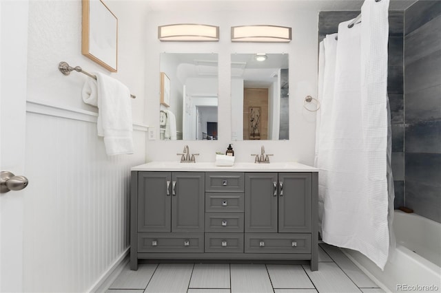 full bathroom featuring double vanity, shower / bathtub combination with curtain, a sink, and tile patterned floors