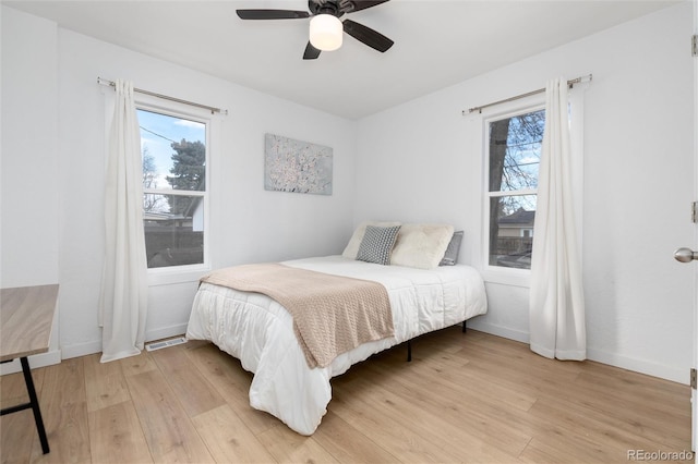 bedroom featuring ceiling fan, light wood-type flooring, and baseboards