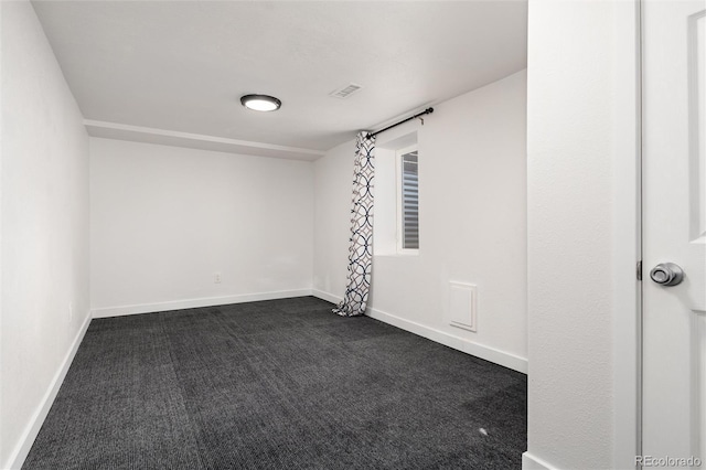 empty room with dark colored carpet, visible vents, and baseboards