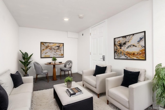 living area featuring light carpet and baseboards