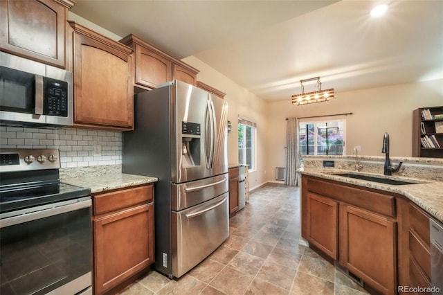 6349 Shooting Iron Way, Colorado Springs, CO 80923 - kitchen featuring appliances with stainless steel finishes, tasteful backsplash, and brown cabinetry