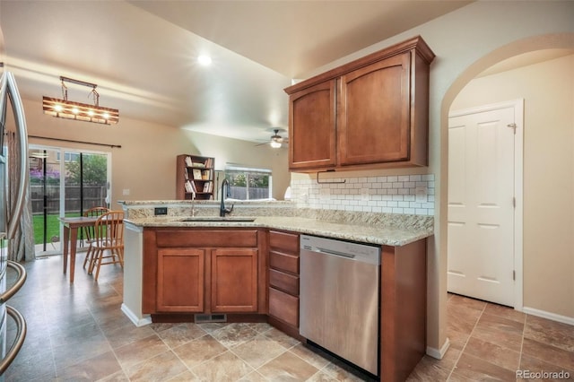 6349 Shooting Iron Way, Colorado Springs, CO 80923 - kitchen featuring stainless steel dishwasher, brown cabinetry, ceiling fan, tasteful backsplash, and a peninsula