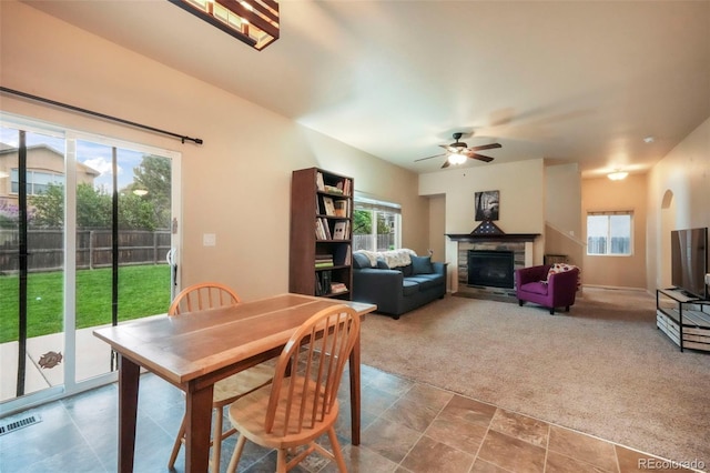 6349 Shooting Iron Way, Colorado Springs, CO 80923 - carpeted dining space featuring a stone fireplace and a ceiling fan