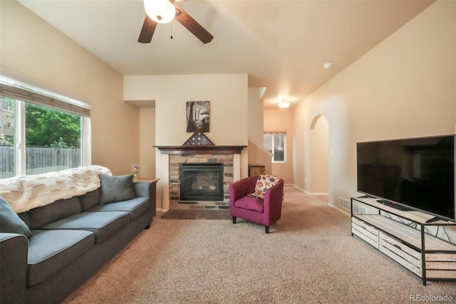 6349 Shooting Iron Way, Colorado Springs, CO 80923 - living room with carpet flooring, a ceiling fan, arched walkways, and a fireplace