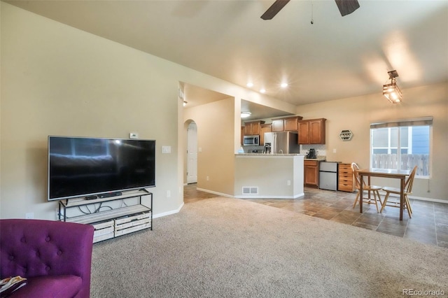 6349 Shooting Iron Way, Colorado Springs, CO 80923 - living room featuring a ceiling fan, light colored carpet, and arched walkways