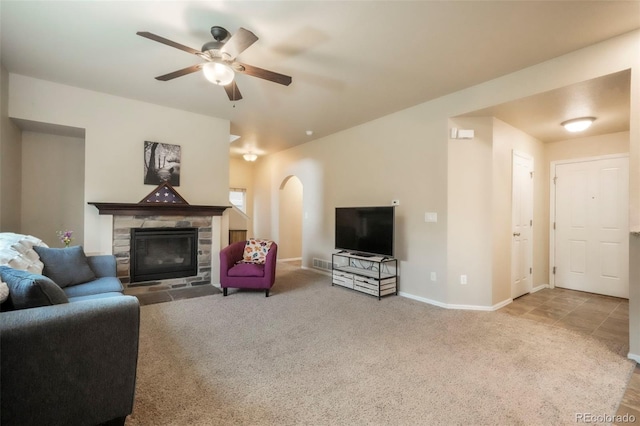 6349 Shooting Iron Way, Colorado Springs, CO 80923 - carpeted living area with arched walkways, ceiling fan, and a fireplace