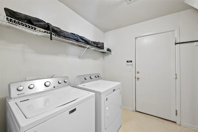 laundry room with washer and dryer and a textured ceiling