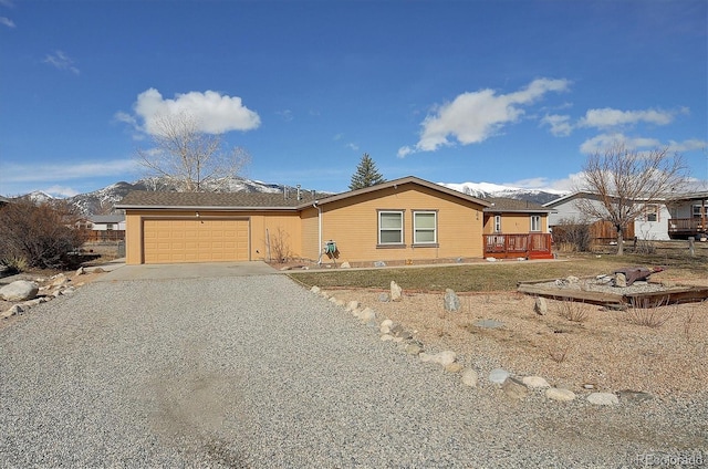 view of front of house with a deck with mountain view and a garage