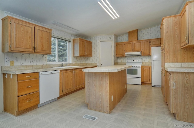 kitchen featuring a center island, white appliances, and sink