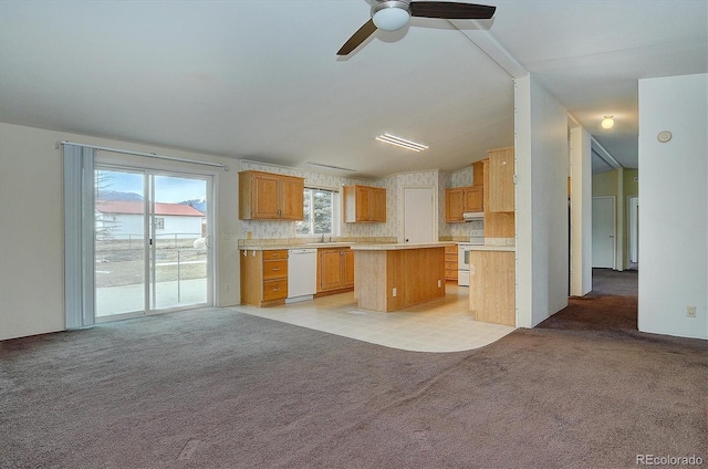 kitchen featuring ceiling fan, sink, light colored carpet, white appliances, and a kitchen island