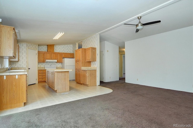 kitchen with a kitchen island, light colored carpet, and white refrigerator