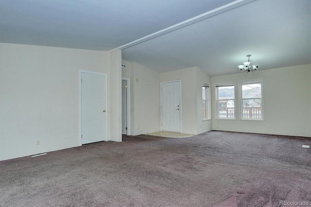 unfurnished living room featuring an inviting chandelier, carpet floors, and vaulted ceiling