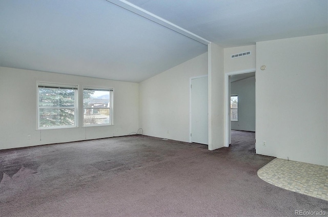 carpeted spare room featuring lofted ceiling