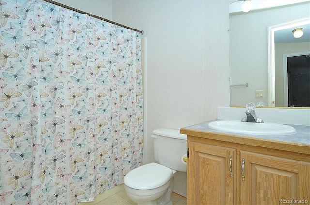 bathroom with vanity, a shower with shower curtain, and toilet