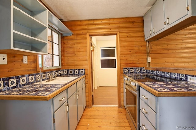 184 Signal Rock Rd, Golden, CO 80403 - kitchen with stainless steel stove, light wood-type flooring, dark countertops, open shelves, and gray cabinets