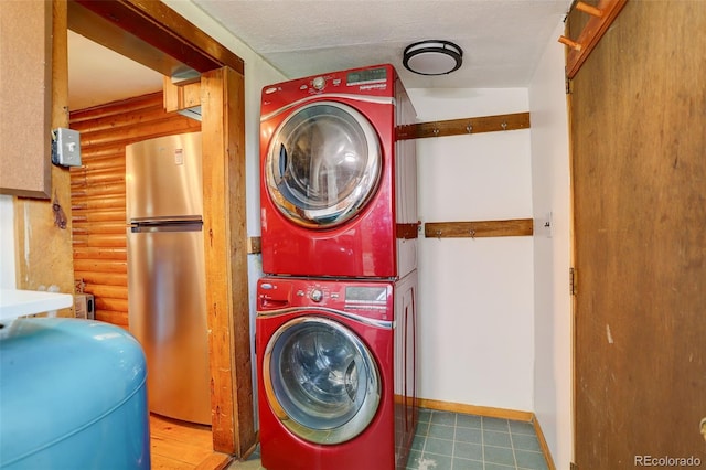 184 Signal Rock Rd, Golden, CO 80403 - laundry area featuring stacked washer and clothes dryer, rustic walls, and tile patterned floors