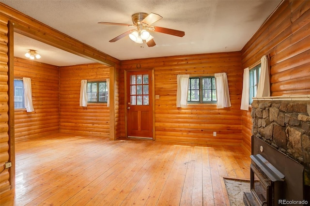184 Signal Rock Rd, Golden, CO 80403 - entrance foyer with light wood-style flooring, a ceiling fan, log walls, a wood stove, and a textured ceiling