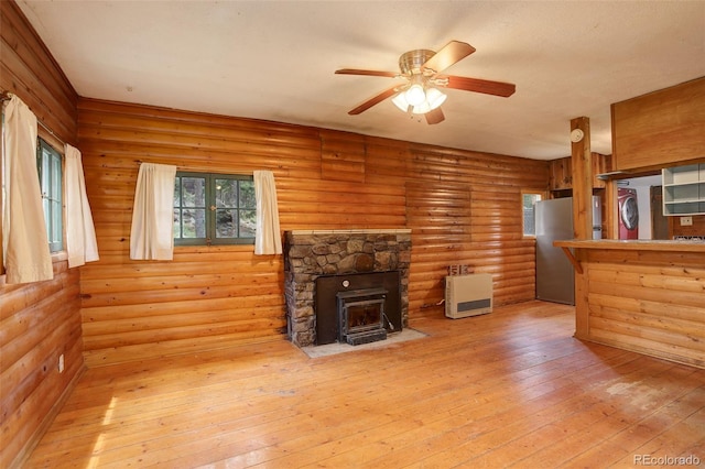 184 Signal Rock Rd, Golden, CO 80403 - unfurnished living room with heating unit, ceiling fan, light wood-style floors, and a wood stove