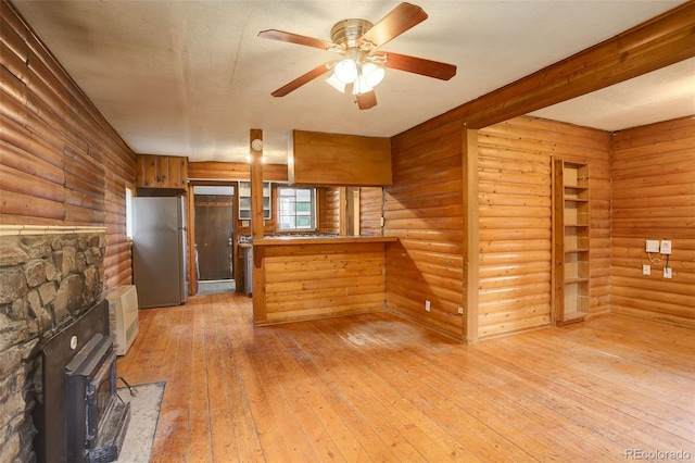 184 Signal Rock Rd, Golden, CO 80403 - kitchen with freestanding refrigerator, a peninsula, light wood-type flooring, a ceiling fan, and a wood stove
