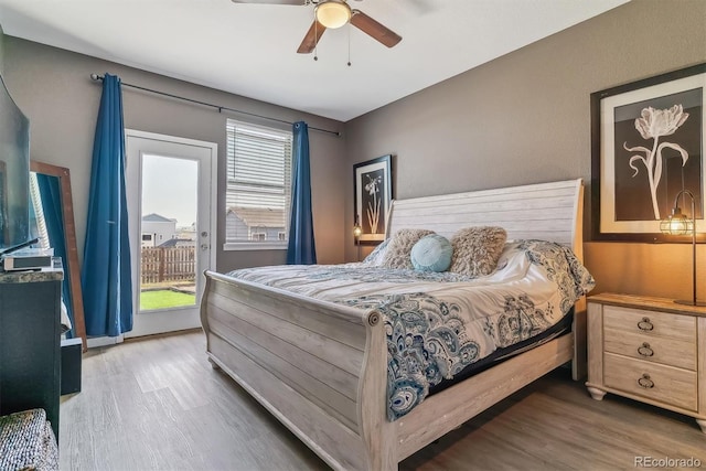 bedroom featuring multiple windows, access to outside, ceiling fan, and hardwood / wood-style flooring