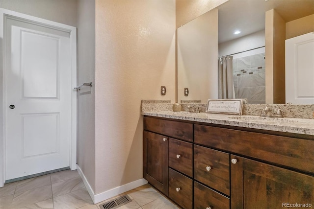 bathroom with a shower with curtain, vanity, and tile patterned flooring