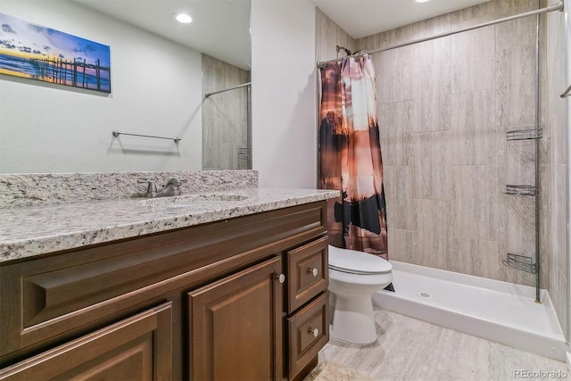 bathroom with wood-type flooring, vanity, a shower with shower curtain, and toilet