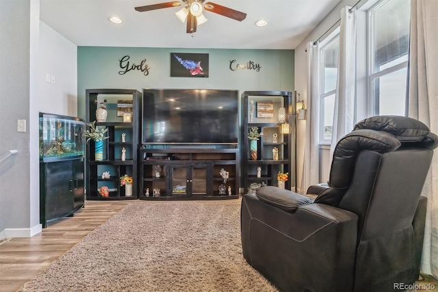 living room with ceiling fan and light hardwood / wood-style flooring