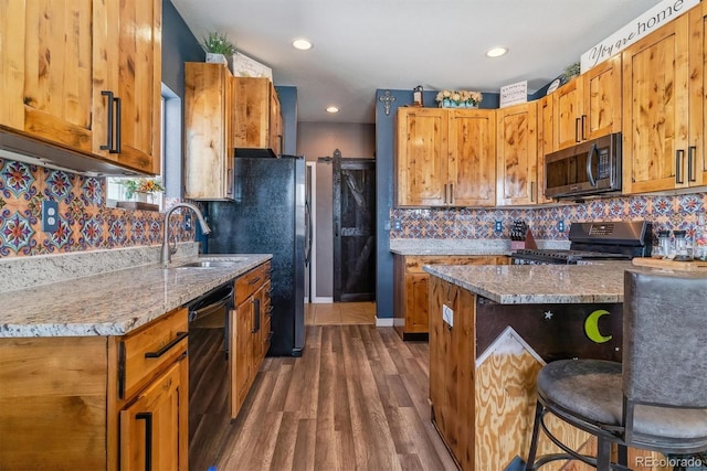 kitchen featuring decorative backsplash, dark hardwood / wood-style flooring, light stone counters, sink, and black appliances