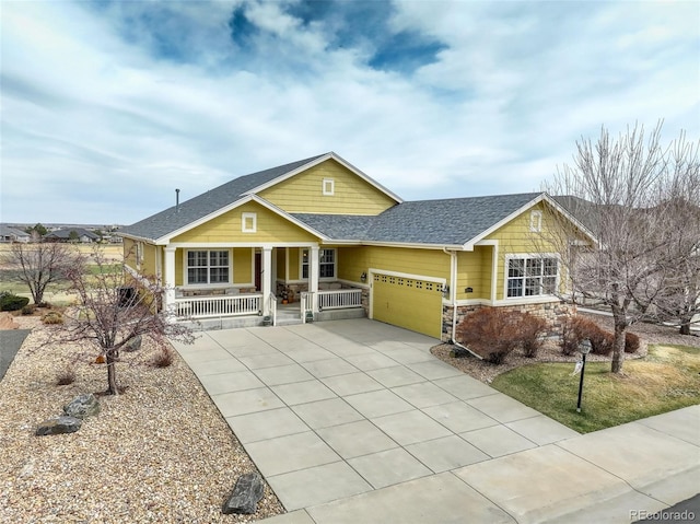15004 Verbena St, Thornton, CO 80602 - view of front of home with a shingled roof, covered porch, driveway, stone siding, and an attached garage