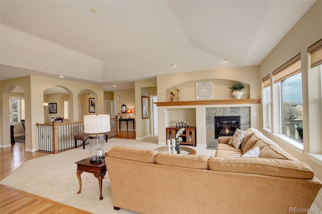 15004 Verbena St, Thornton, CO 80602 - living area featuring a tiled fireplace, wood finished floors, baseboards, and arched walkways