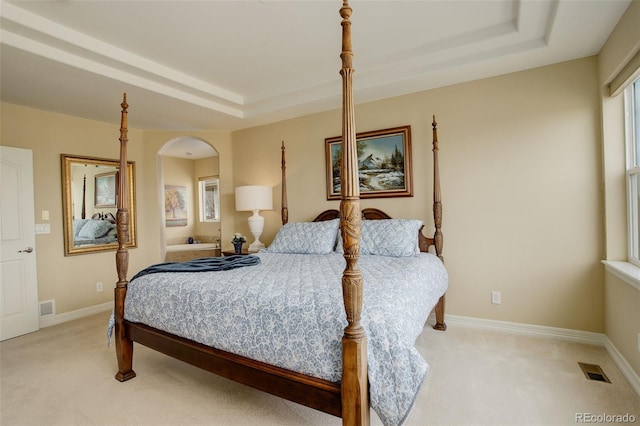 15004 Verbena St, Thornton, CO 80602 - bedroom featuring arched walkways, visible vents, light colored carpet, and a tray ceiling