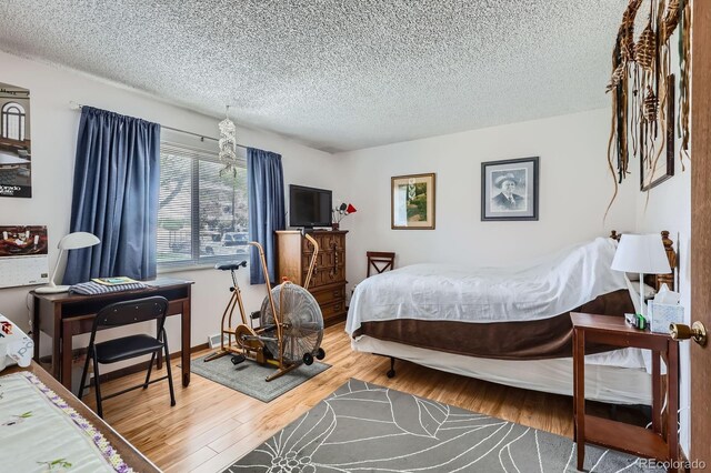 6330 E Wesley Ave, Denver, CO 80222 - bedroom with a textured ceiling and wood finished floors