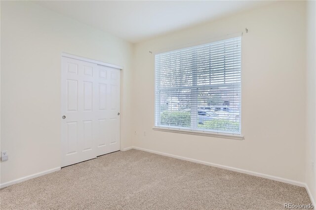 9907 Martin Luther King Blvd Unit 103, Denver, CO 80238 - unfurnished bedroom with light colored carpet, baseboards, and a closet