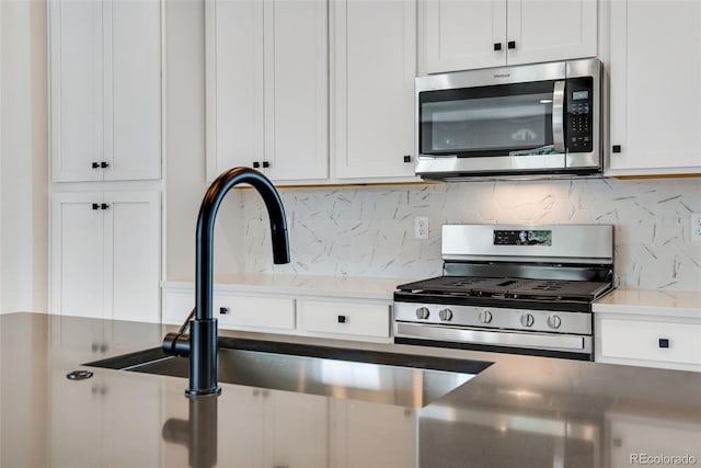 kitchen featuring white cabinetry, stainless steel appliances, sink, and tasteful backsplash