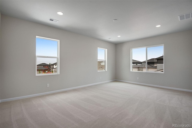 unfurnished room featuring light colored carpet