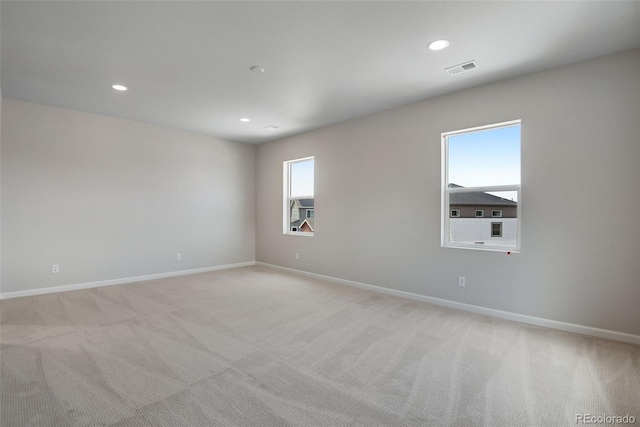 spare room featuring light carpet