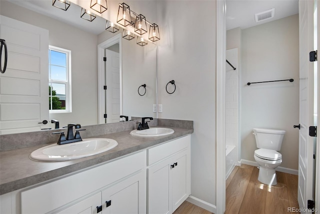 full bathroom with wood-type flooring, toilet, tub / shower combination, and vanity