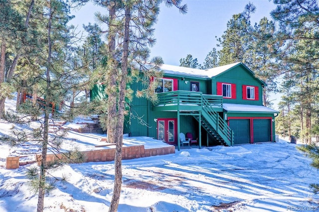 view of front facade featuring french doors, a garage, and a wooden deck