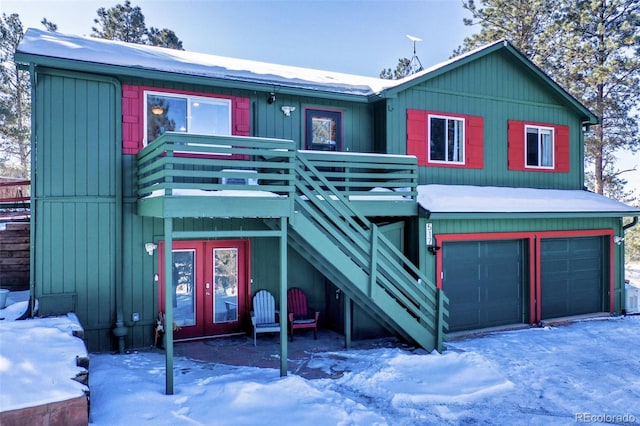 chalet / cabin with an attached garage, stairway, and a wooden deck