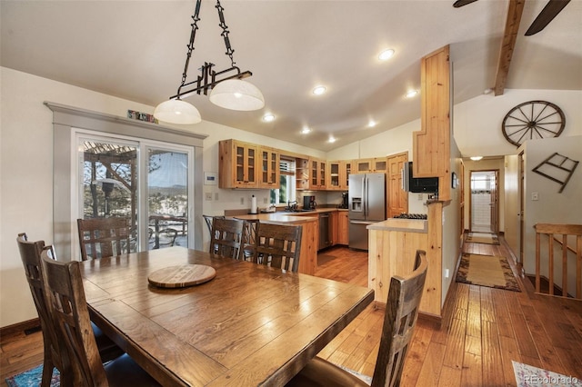 dining room featuring lofted ceiling with beams, sink, and light hardwood / wood-style floors