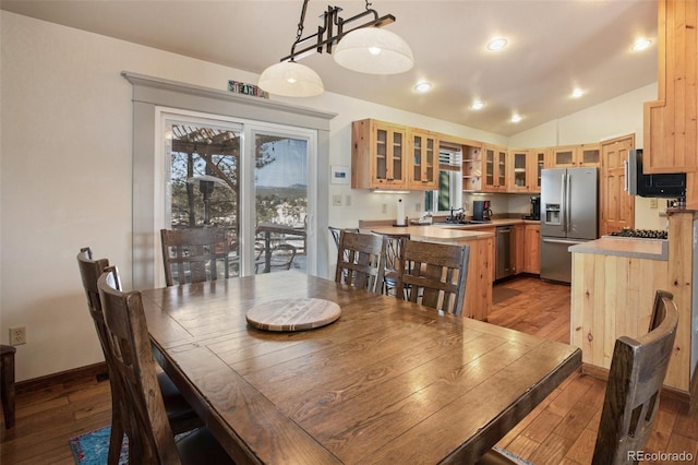 dining space with lofted ceiling, sink, and light hardwood / wood-style flooring