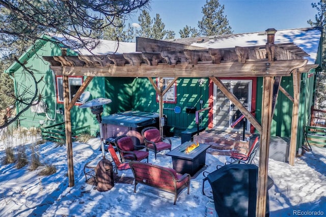 snow covered patio with an outdoor fire pit