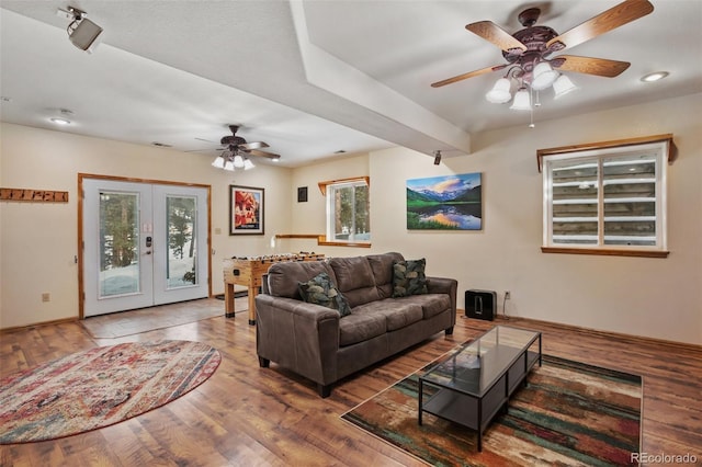 living room with dark wood-type flooring, french doors, and ceiling fan